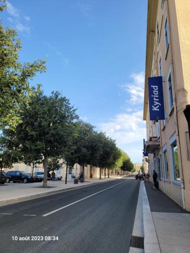 an empty street with trees on the side of a building at KYRIAD ORANGE Centre Ville - HOTEL & RESTAURANT & BAR - La Galerie d'Art des Princes - Provence Alpes Côte d'Azur - France - Proche A7-A9 - exit21- Châteauneuf-du-Pape Avignon Bollene Nimes - 24h-24h in Orange