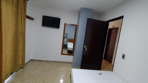 Habitación con puerta y espejo en la pared. en Hotel Medellin Kapital, en Medellín
