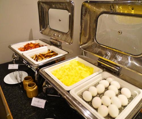 a buffet with eggs and other food on a counter at Hotel Kaiserin Augusta in Weimar