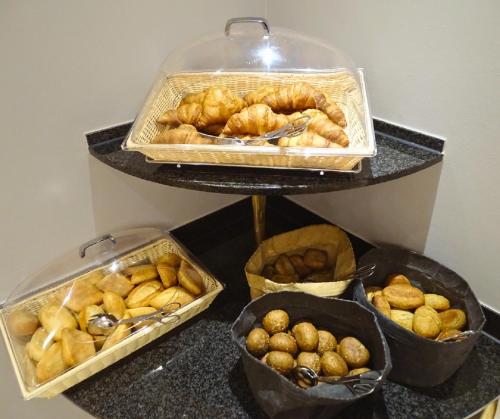 a group of trays of bread and pastries on a counter at Hotel Kaiserin Augusta in Weimar