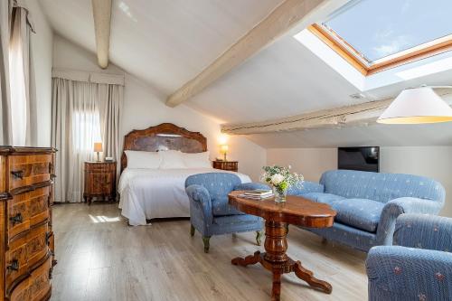a bedroom with a bed and blue chairs and a table at Hotel Villa Mabapa in Venice-Lido
