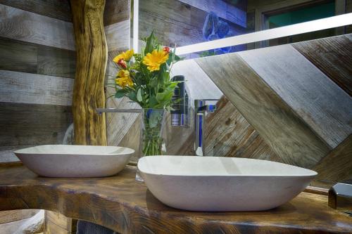 a bathroom with two sinks and a vase of flowers at Hotel Kocourkov in Hlinsko