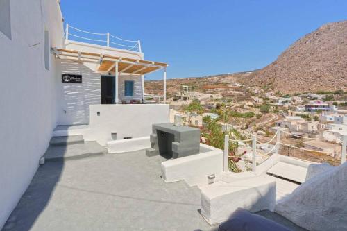 a balcony with white furniture and a view of a city at Medusa traditional house in Emporio
