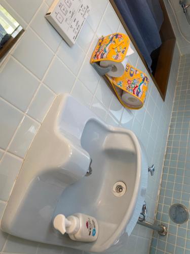 a bathroom with a urinal and a childs toy in it at Sun Sea GuestHouse in Yomitan