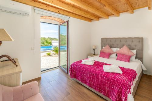ein Schlafzimmer mit einem Bett mit einer roten Decke in der Unterkunft Villa Rodrigues in Boliqueime