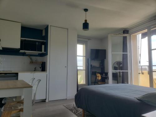 une chambre avec un lit et une table et une cuisine dans l'établissement LE VINCI Studio tout confort proche centre ville avec terrasse et parking, à Blois