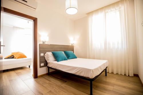 RESIDENCE VILLA TOTA في سبوليتو: غرفة نوم مع سرير ووسائد زرقاء ونافذة
