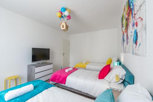 - 2 lits dans une chambre avec une télévision et une chambre avec 2 lits dans l'établissement Wonderland By Plaza, à Chessy