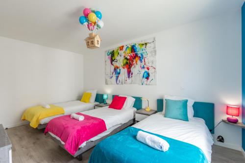 deux lits dans une chambre avec un tableau au mur dans l'établissement Wonderland By Plaza, à Chessy