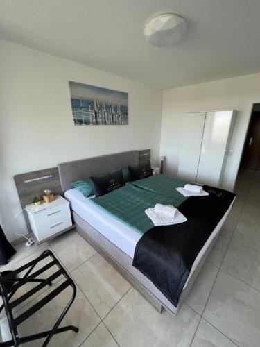 1 dormitorio con 1 cama grande con sábanas verdes y silla en Ferien-Whg Seeadler direkt am Meer, mit Meerblick, en Steinhude
