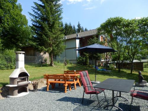 a patio with a table and chairs and a grill at Ferienhaus Bella Vista in Presseggersee