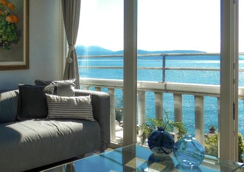 薩羅的住宿－Luxury Apartment right on the water Maddalena，带沙发的客厅,享有海景