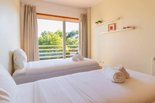 two beds in a room with a window at Casa da Praça in the center of Porto - GuestSPA in Porto