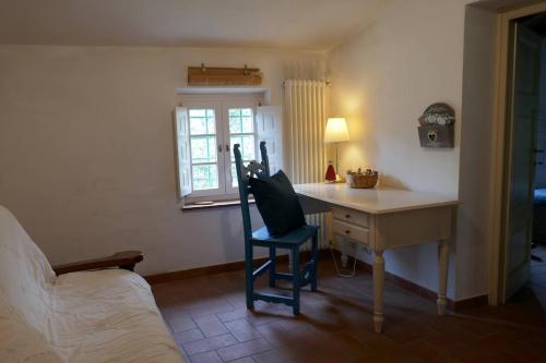 a bedroom with a desk and a chair next to a bed at Casa spaziosa in caratteristico paesino di alta collina in Santa Maria Albiano
