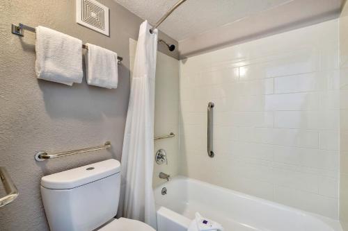 a bathroom with a toilet and a tub and a sink at Studio 6 Effingham, IL in Effingham