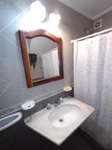 a bathroom with a sink and a mirror at Cabañas del Paraiso in Colón