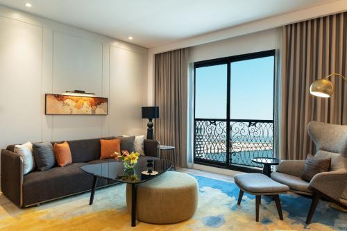 a living room with a couch and a table at Le Royal Méridien Place Vendôme Lusail in Doha