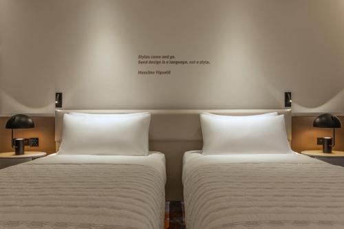 two beds sitting next to each other in a room at Le Royal Méridien Place Vendôme Lusail in Doha