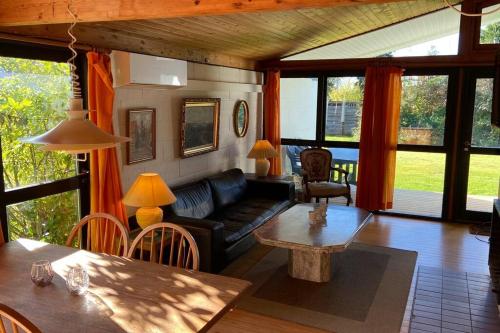 ein Wohnzimmer mit einem Sofa und einem Tisch in der Unterkunft Sommerhus, Hornbæk in Hornbæk