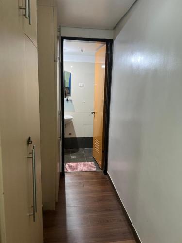 a hallway with a door leading to a bathroom at Eton Emerald Loft ortigas in Manila