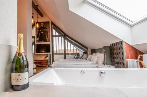 a bottle of champagne sitting on a bath tub in a room at Hirschen Erlinsbach Swiss Quality in Erlinsbach