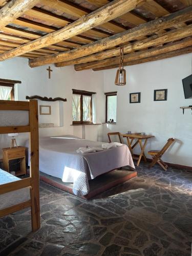 a bedroom with a large bed and a table at La Hoyada in Tilcara