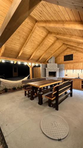 a large wooden picnic table in a building with a fireplace at Zillya Club in Tatariv