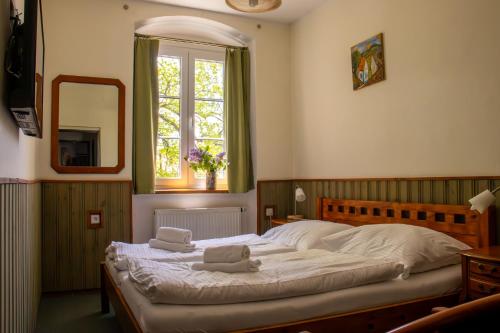 a bedroom with a bed with two towels on it at Penzion Zvonice Hojná Voda in Horní Stropnice