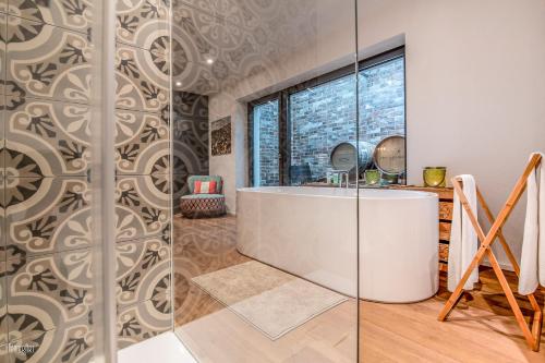 a bathroom with a tub and a glass wall at Hirschen Erlinsbach Swiss Quality in Erlinsbach