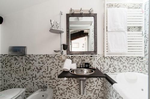a bathroom with a sink and a tub and a mirror at La Mansardina di Giuly by Quokka 360 - bright attic apartment in the centre of Como in Como