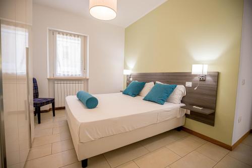 a bedroom with a large bed with blue pillows at RESIDENCE VILLA TOTA in Spoleto