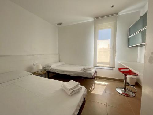 a white room with two beds and a window at Casas Del Mar in Oliva