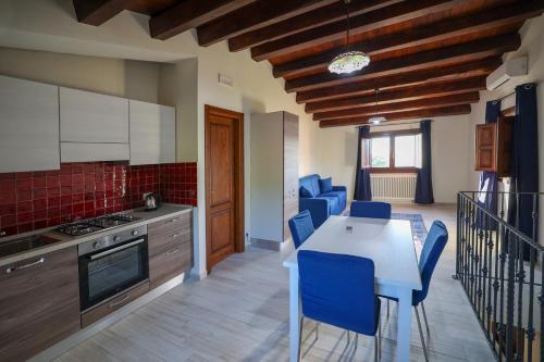 a kitchen with a white table and blue chairs at Agriturismo Case Rapputi in Lascari