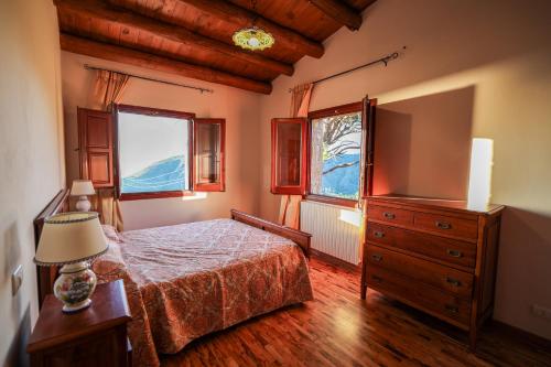 a bedroom with a bed and a dresser and a television at Agriturismo Case Rapputi in Lascari