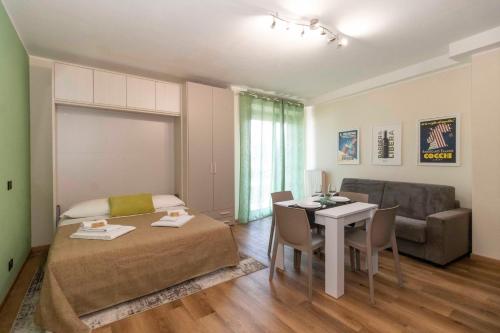 a room with a bed and a table and a couch at Torino Comfy Apt - w/ Private Parking in Turin