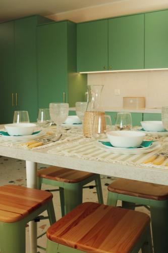 a kitchen with green cabinets and a table with plates and glasses at Malta Lake - Apartment in Poznań