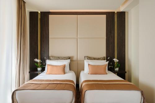 two beds sitting next to each other in a room at Hotel The Square Milano Duomo - Preferred Hotels & Resorts in Milan