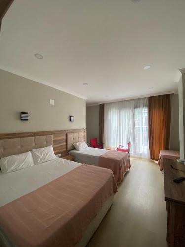 a hotel room with two beds and a window at Can Butik Otel in Ardeşen