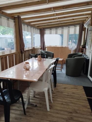 a dining room with a table and chairs at Mobil-home tout confort à 300m de l'océan in Saint-Brevin-les-Pins