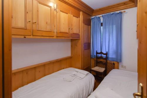 um quarto com 2 camas e uma cortina azul em Cà Enrosadira primo piano em San Vito di Cadore