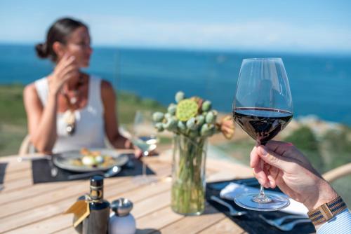 a person holding a glass of wine at a table at Petram Resort & Residences in Savudrija
