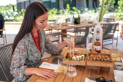 a woman sitting at a table with a plate of food at Petram Resort & Residences in Savudrija