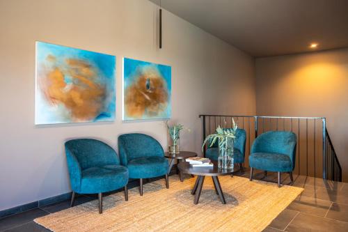 a waiting room with blue chairs and a table at Petram Resort & Residences in Savudrija