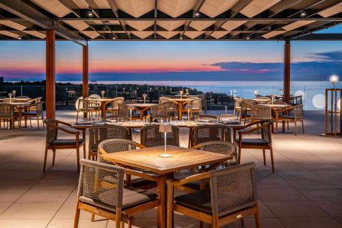 um restaurante com mesas e cadeiras num telhado em Petram Resort & Residences em Savudrija