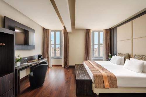 a hotel room with a bed and a desk at Hotel The Square Milano Duomo - Preferred Hotels & Resorts in Milan
