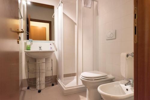 a white bathroom with a toilet and a sink at Dimore Verona in Verona