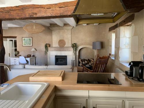 a kitchen with a counter top and a living room at Maison chaleureuse entre la Touraine et le Berry in Martizay