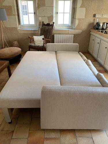 a large white bed in a room with windows at Maison chaleureuse entre la Touraine et le Berry in Martizay