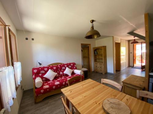 a living room with a red couch and a table at Domaine de Rozan - Col de Porte, Chartreuse - Grenoble in Sarcenas