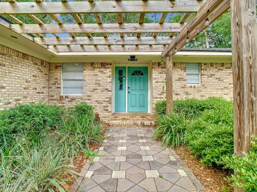 a brick house with a blue door and a wooden pergola at Close to Everything! Family & Pet Friendly Home - By the Park! in Saint Augustine